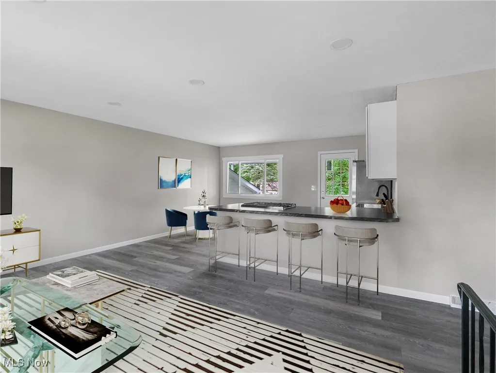 Living area with dark wood-type flooring and baseboards