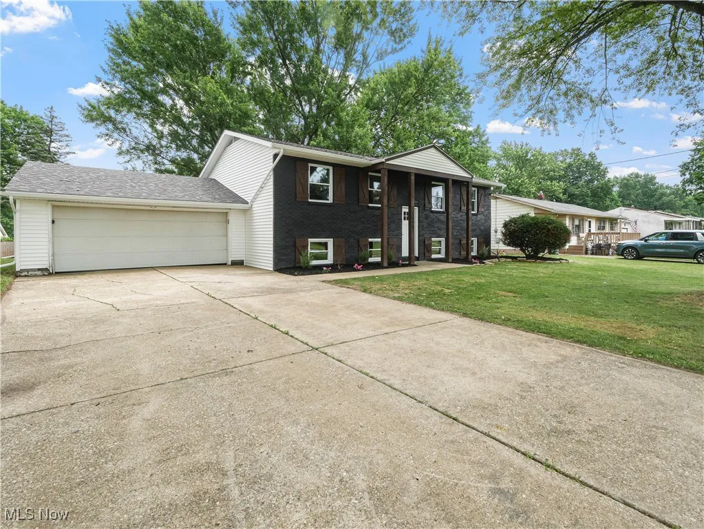 Split foyer home with driveway, a front yard, and an attached garage