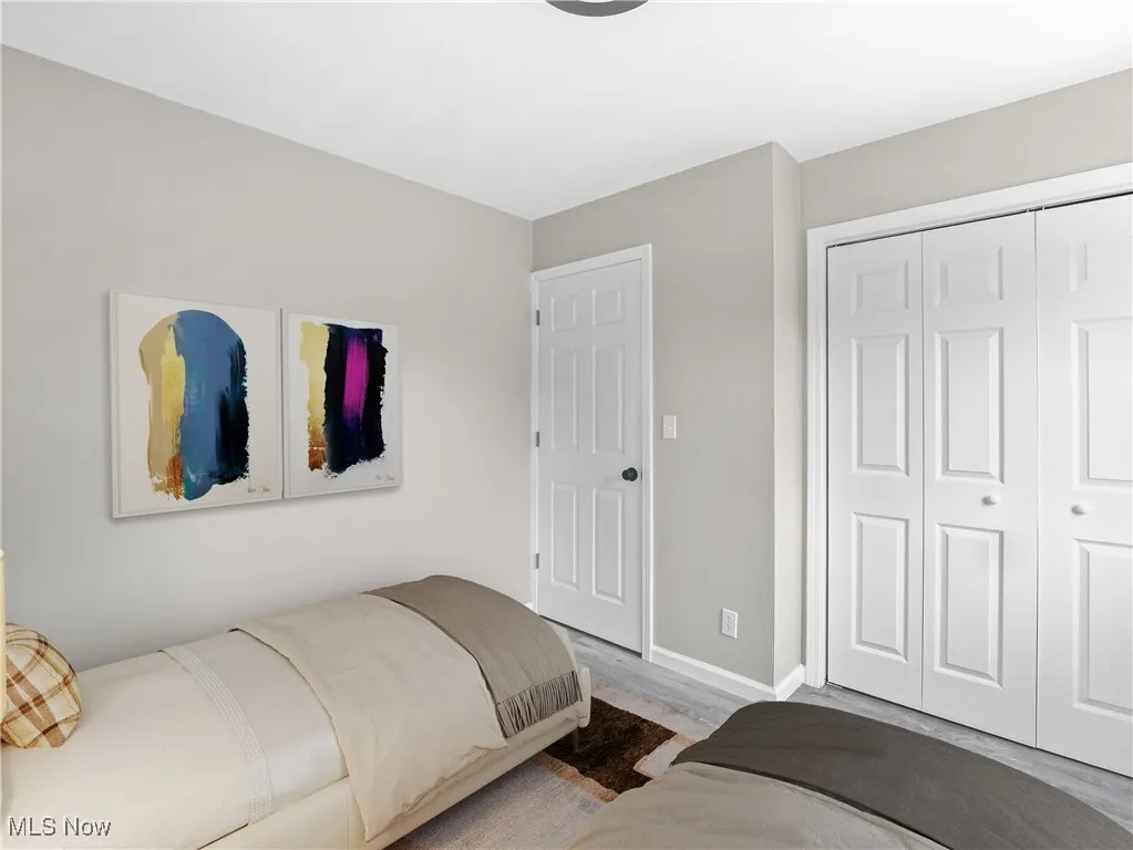 Bedroom featuring wood finished floors and a closet