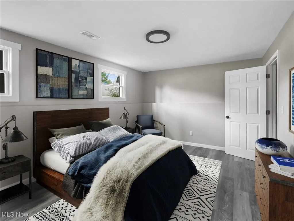 Bedroom with dark wood-style flooring and baseboards