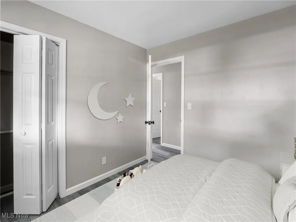 Bedroom with wood finished floors and baseboards
