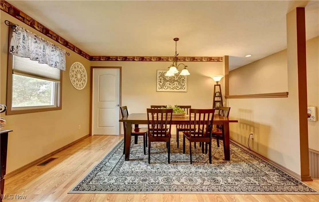 Dining room featuring wood finished floors and a chandelier