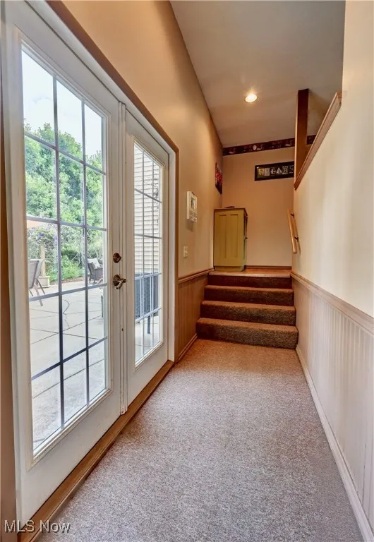 Doorway with a wainscoted wall, plenty of natural light, stairs, carpet floors, and recessed lighting