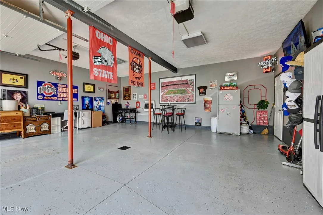 Garage with a garage door opener and freestanding refrigerator