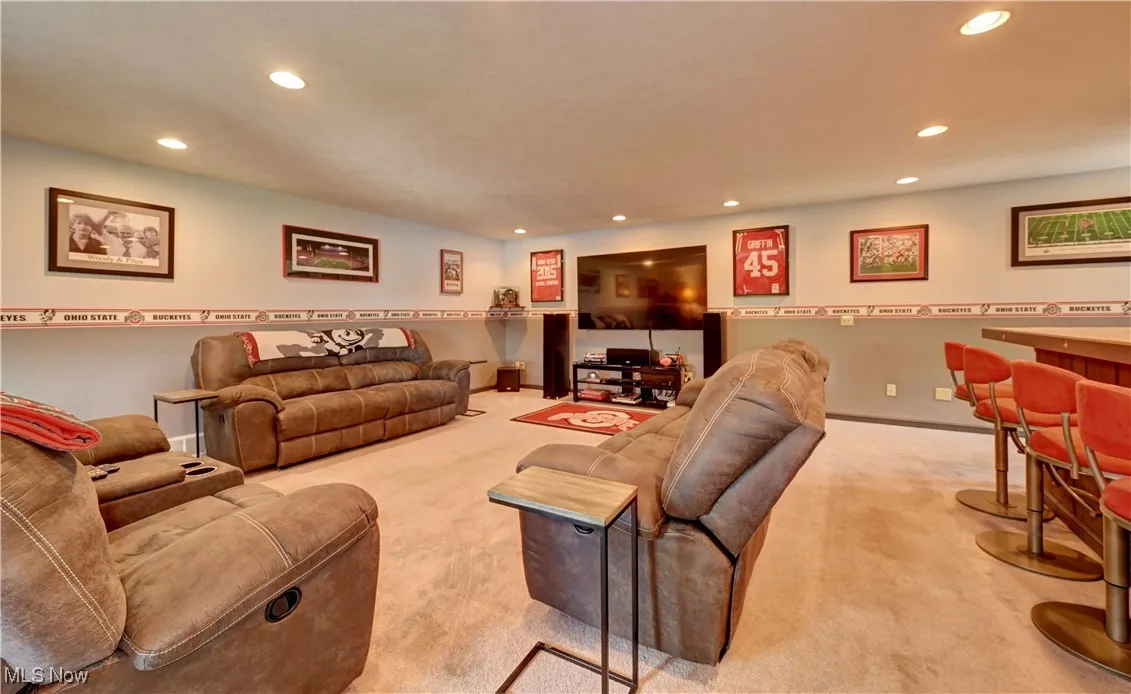 Carpeted living area with recessed lighting and baseboards