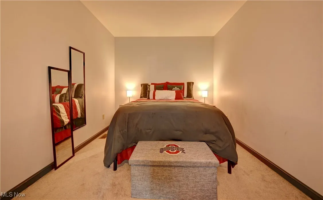 Bedroom featuring light carpet