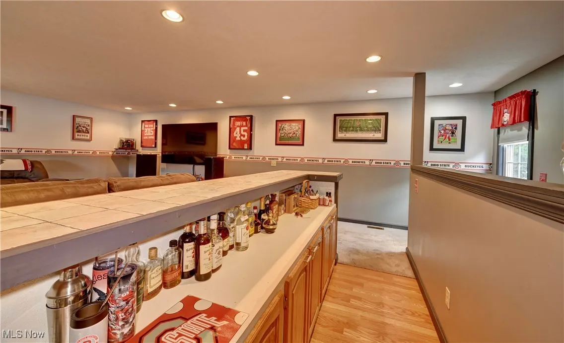 Bar area with recessed lighting and light wood-style flooring