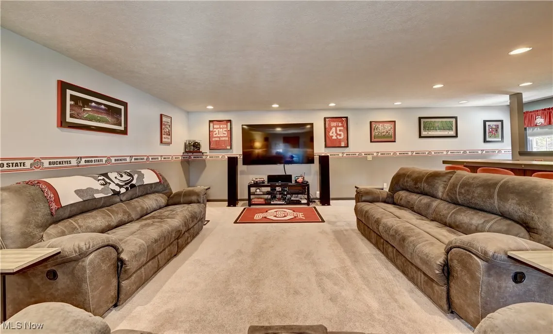 Carpeted living area with recessed lighting and baseboards