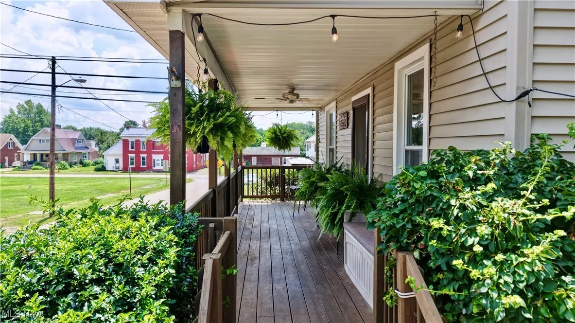 Wooden porch with a ceiling fan and a residential view