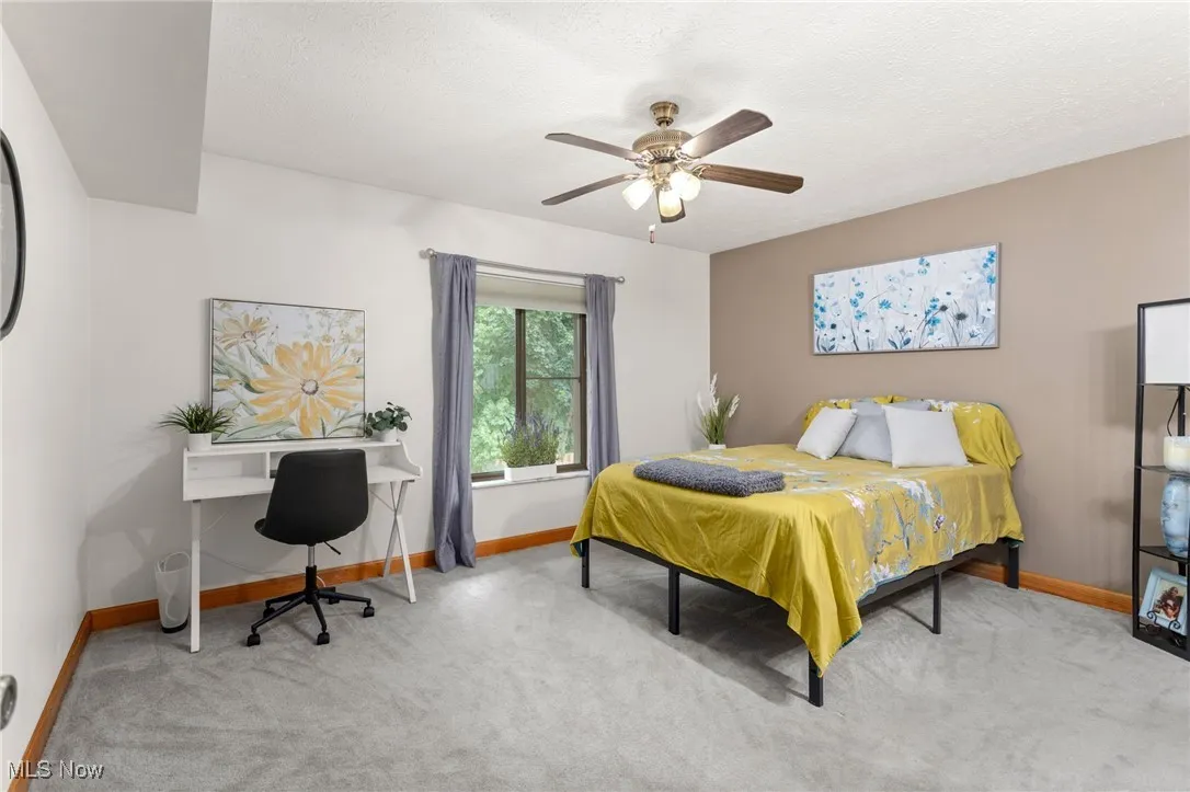 Bedroom featuring carpet flooring, ceiling fan, and a desk