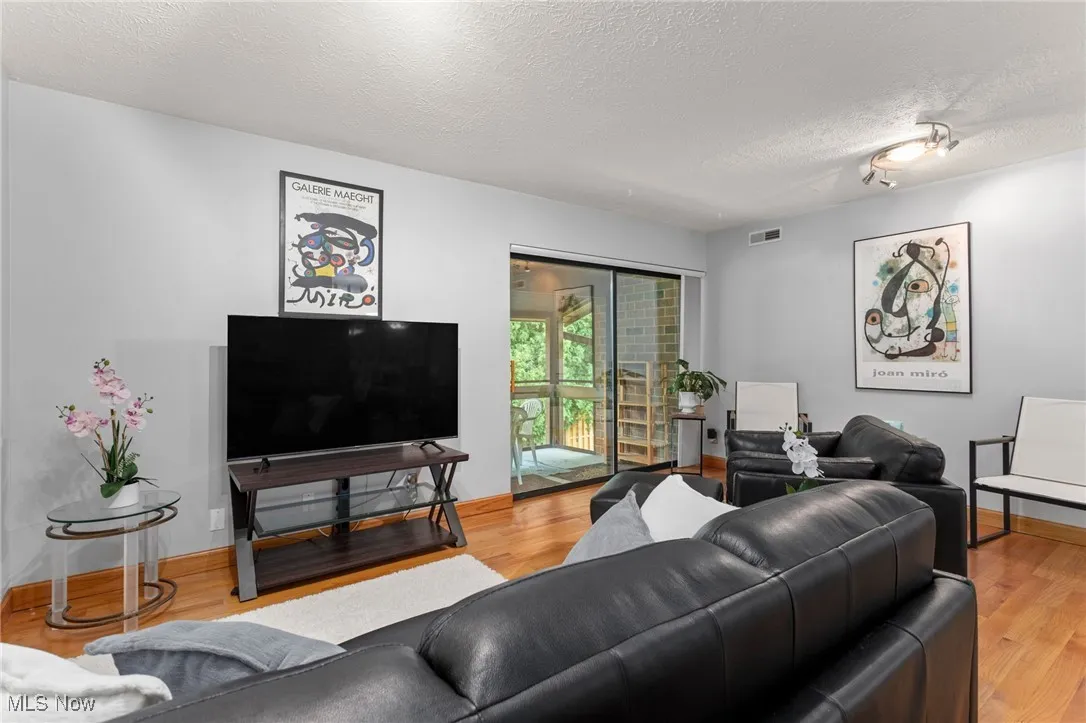 Living room featuring a textured ceiling and wood finished floors