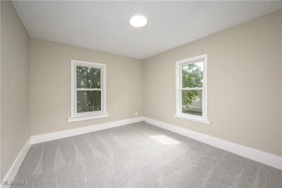 Unfurnished room featuring carpet and a textured ceiling