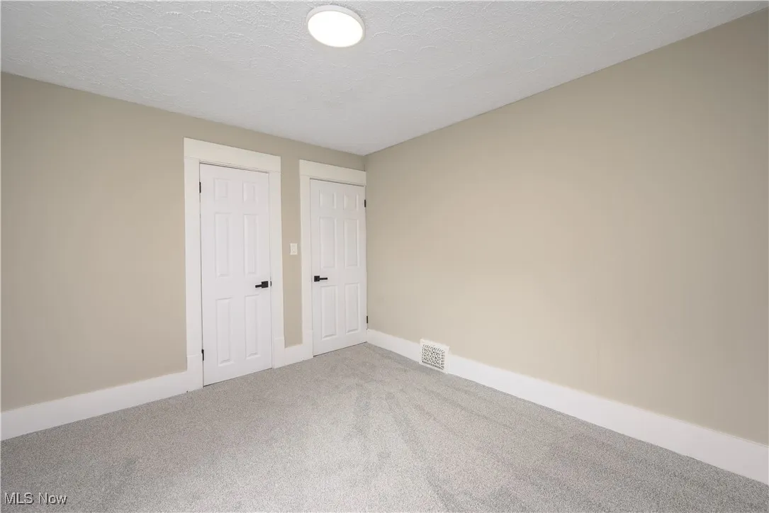 Unfurnished bedroom featuring carpet floors and a textured ceiling
