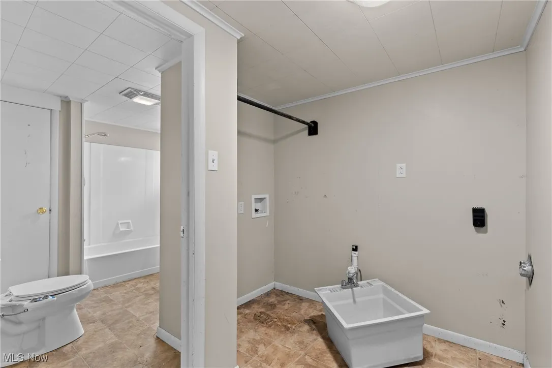 Laundry area featuring washer hookup and crown molding