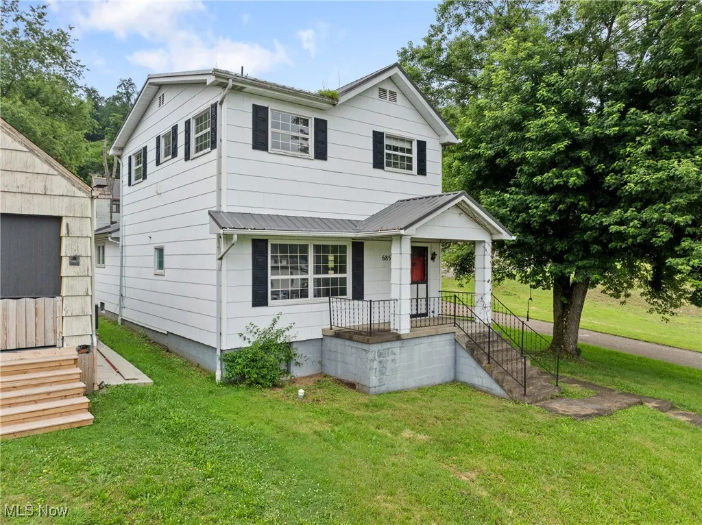 View of front of house with a front yard and a metal roof