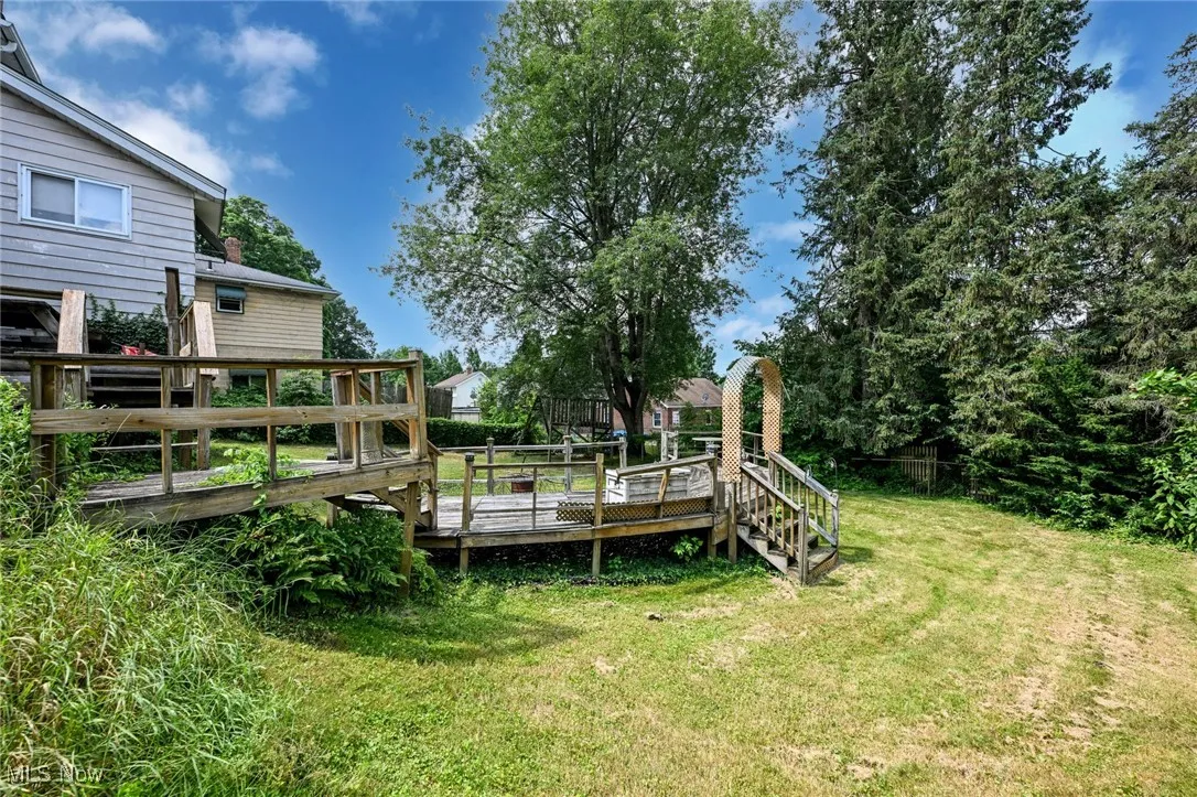 View of green lawn featuring a deck