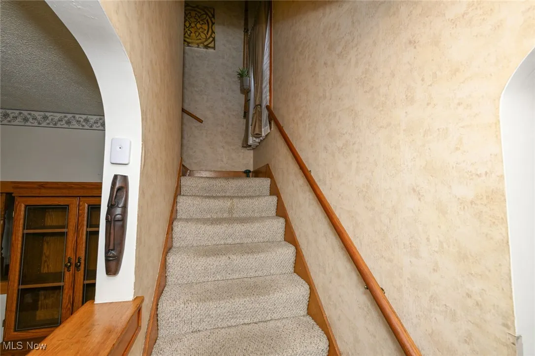 Stairs with arched walkways and wallpapered walls