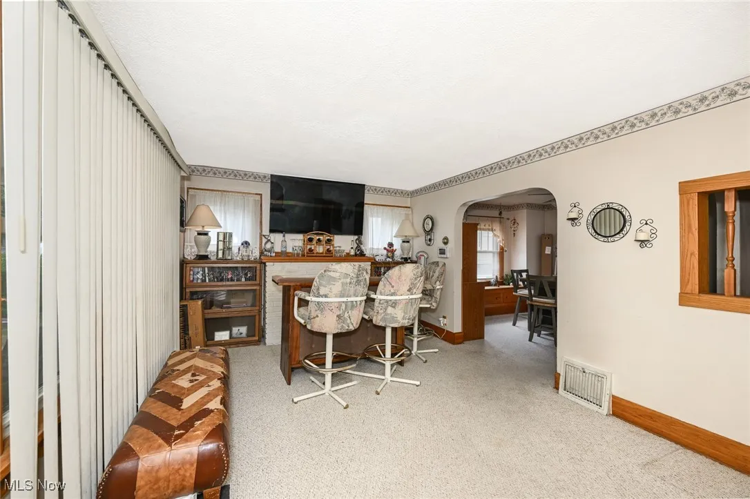 Dining area with arched walkways and carpet