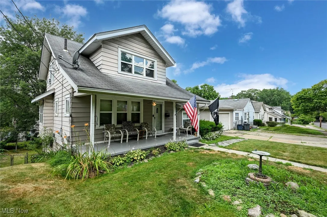 View of front facade featuring a porch, a front yard, and concrete driveway
