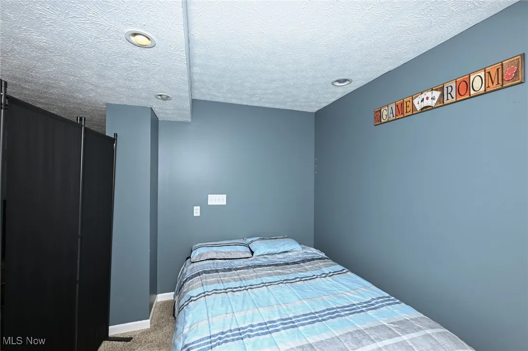 Bedroom with carpet floors, a textured ceiling, and recessed lighting
