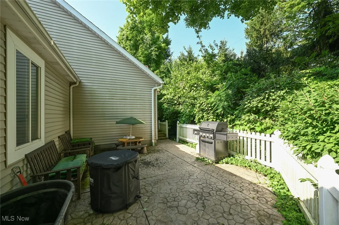 Fenced backyard with a patio area and grilling area