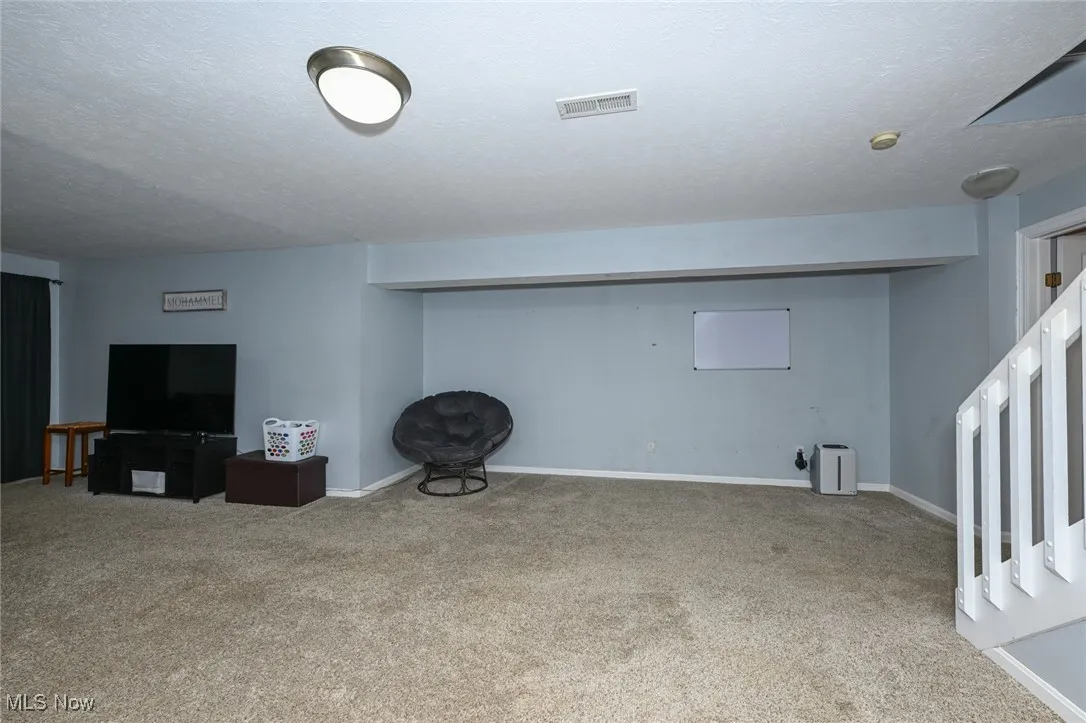 Finished below grade area featuring carpet floors and a textured ceiling