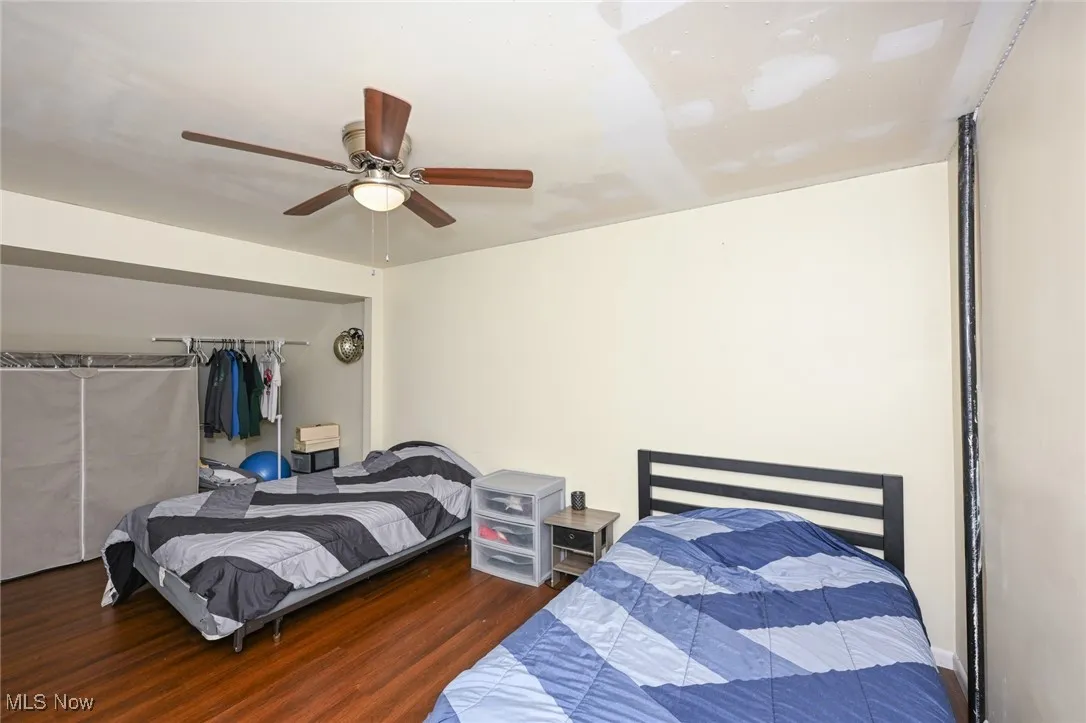 Bedroom with wood finished floors, a closet, and a ceiling fan