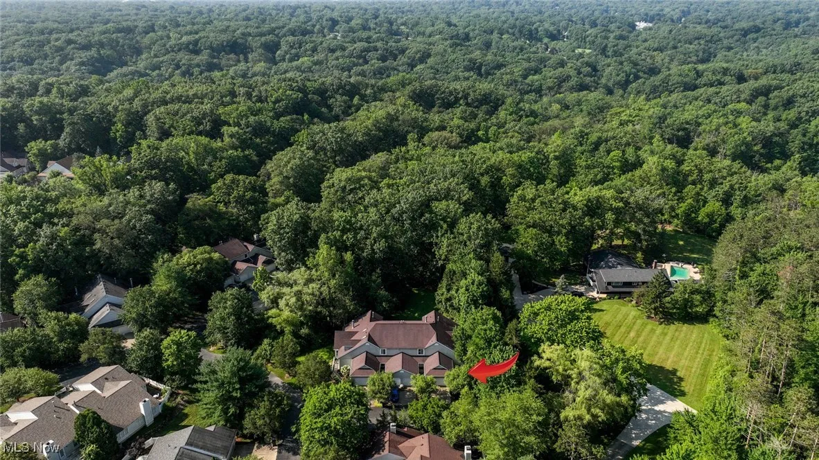 Aerial view of property's location with a heavily wooded area