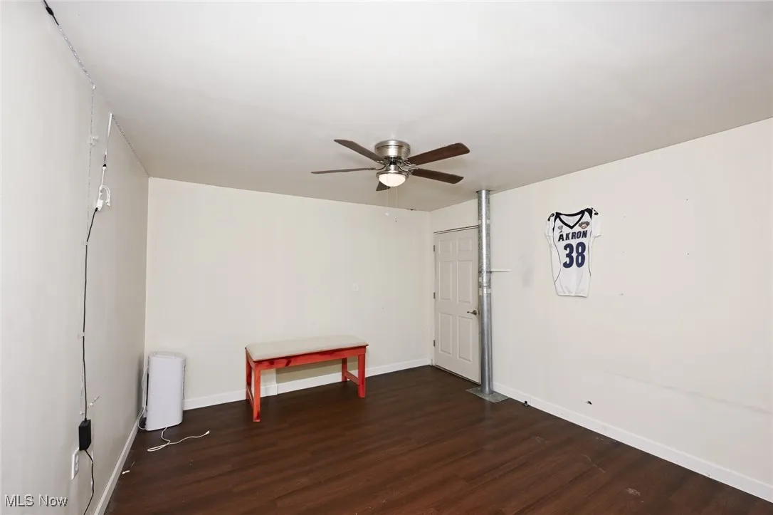 Unfurnished room with wood finished floors and a ceiling fan