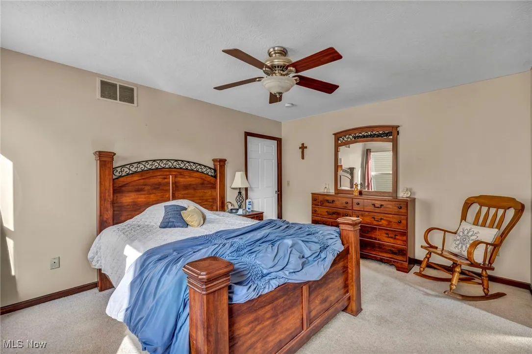 Bedroom with light carpet and a ceiling fan