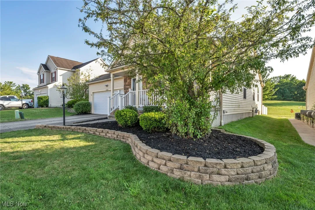 View of front of house featuring driveway, a front lawn, and a garage