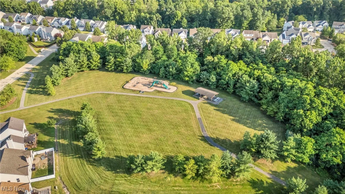 Aerial view of property and surrounding area with nearby suburban area and a recreational park