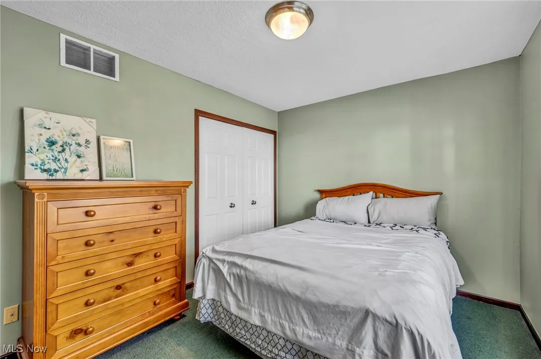 Bedroom with dark carpet and a closet