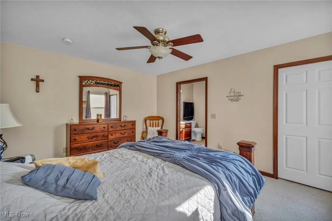Bedroom with light carpet and a ceiling fan