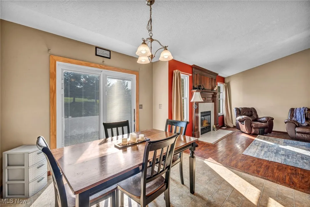Dining space featuring a fireplace with flush hearth and a textured ceiling