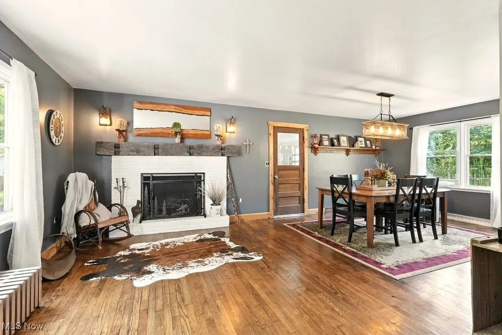 Living Room with Brick Wood-Burning Fireplace with Hearth and View of Dining Room