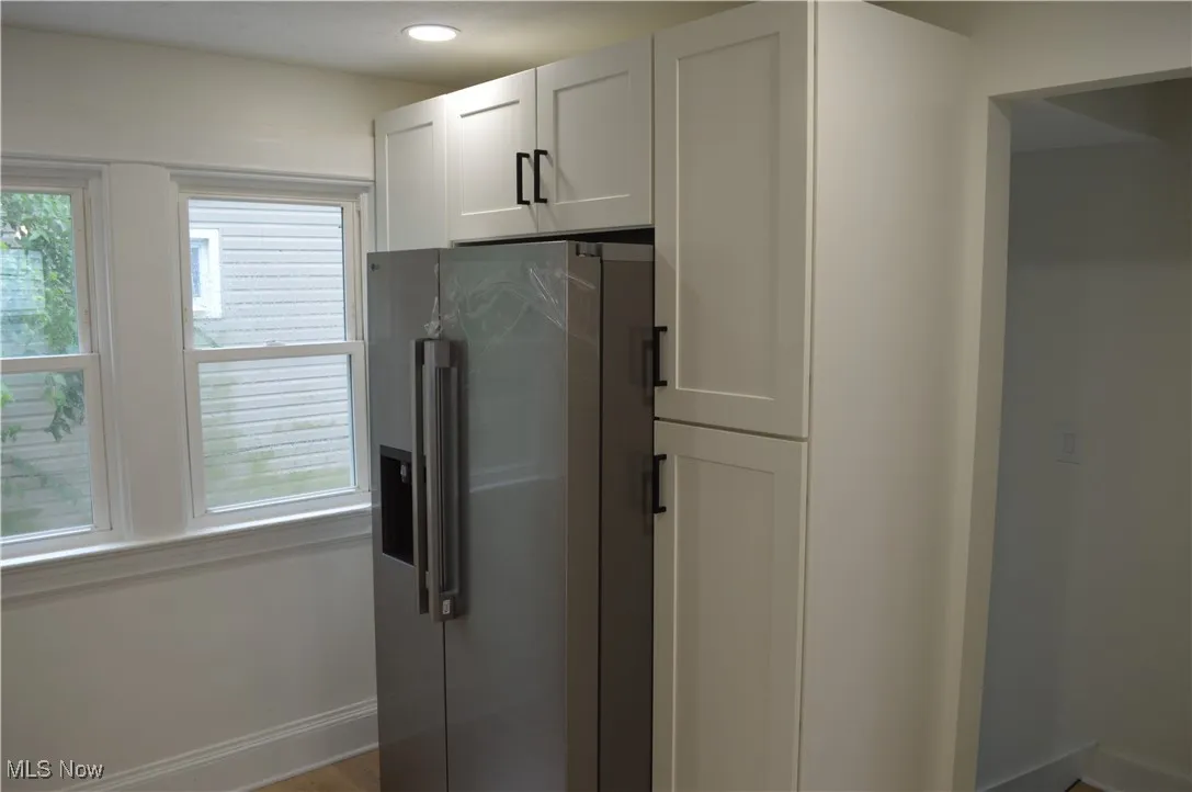 Kitchen featuring high end refrigerator, white cabinetry, and recessed lighting
