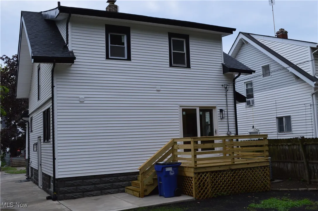 Rear view of house featuring a chimney and a deck