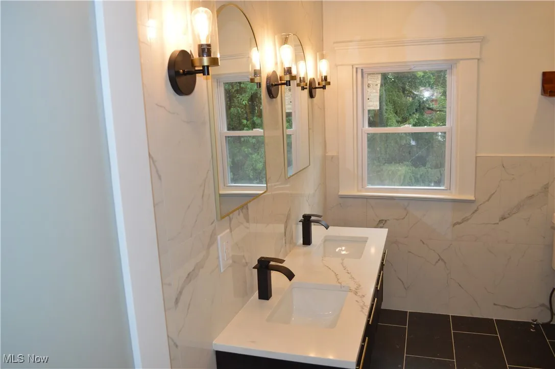 Bathroom featuring double vanity and a chandelier