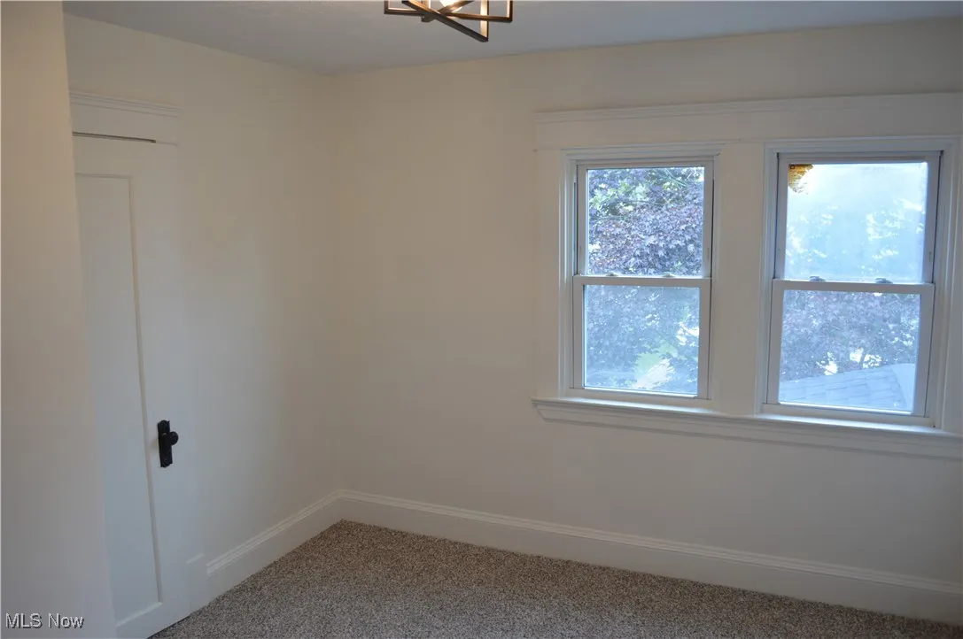 Carpeted spare room featuring baseboards