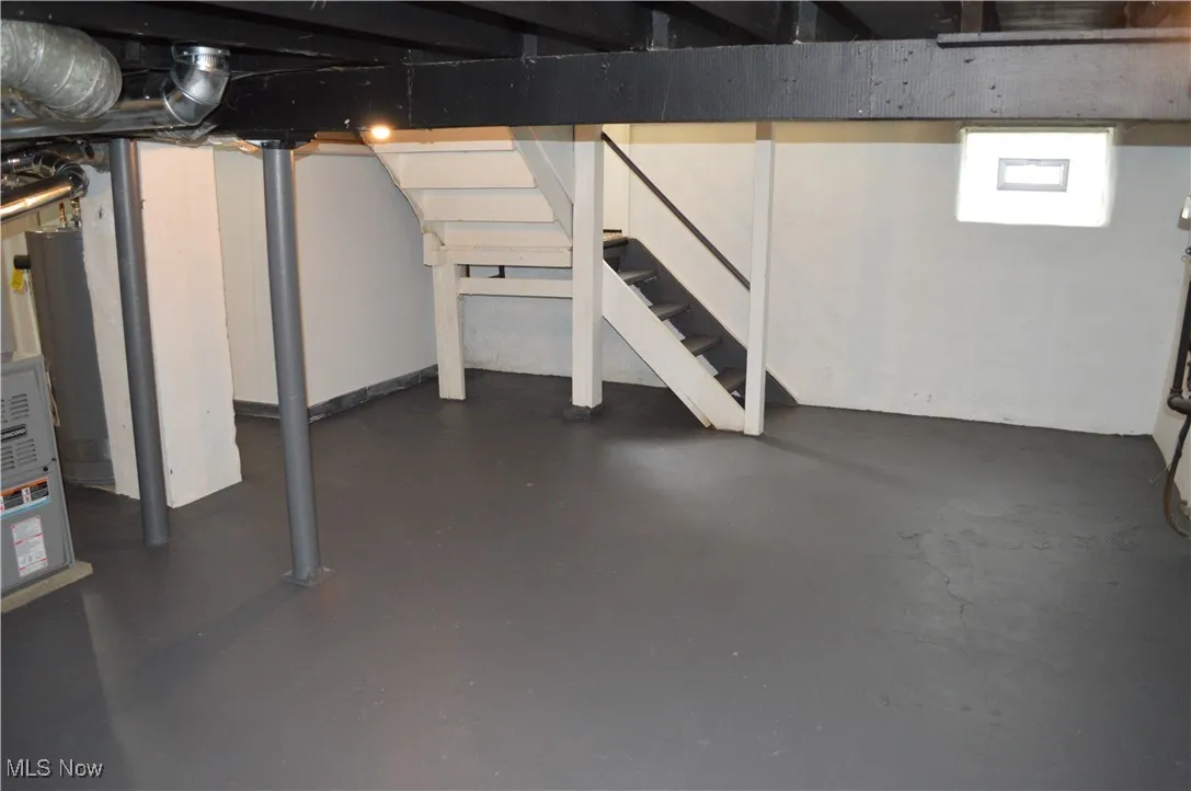 Unfinished below grade area featuring stairway