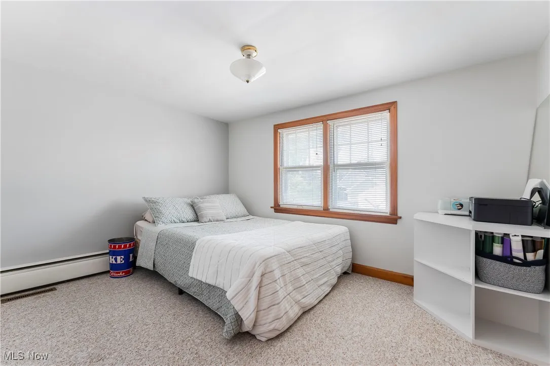 Carpeted bedroom with a baseboard radiator