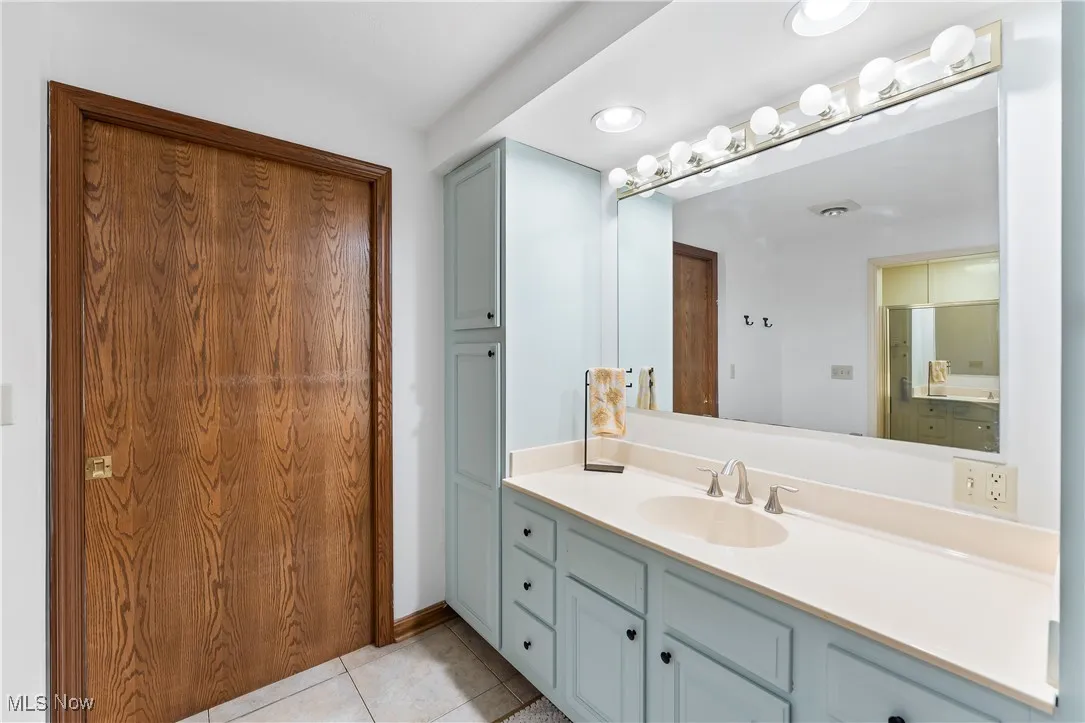 Bathroom with vanity, tile patterned floors, and recessed lighting