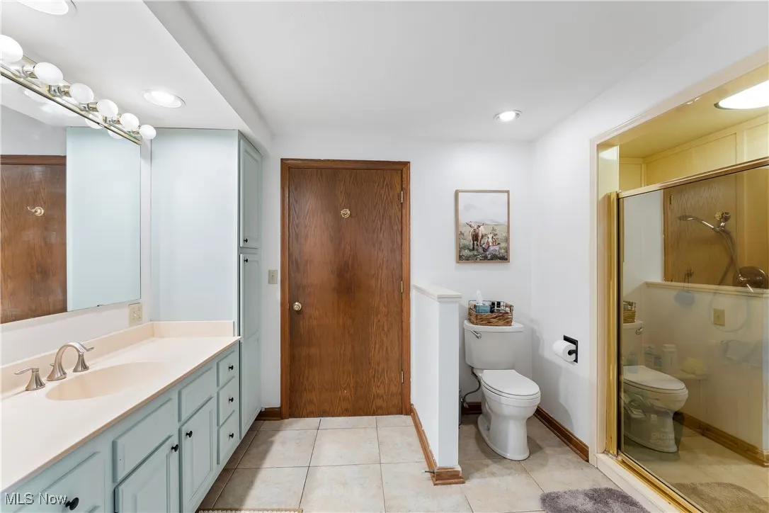 Bathroom with vanity, tile patterned flooring, a stall shower, and recessed lighting