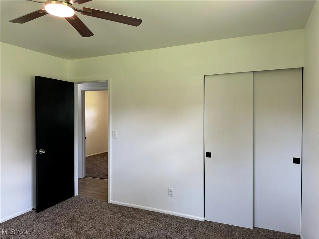 Unfurnished bedroom featuring carpet floors, a closet, and ceiling fan