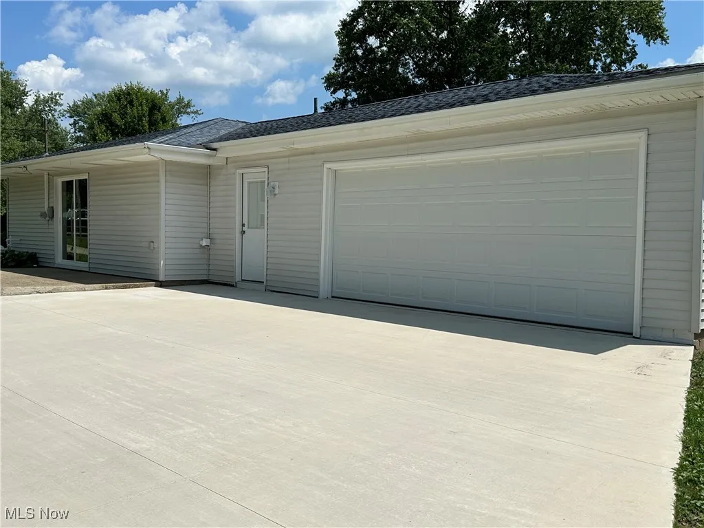 View of front facade featuring concrete driveway and a garage