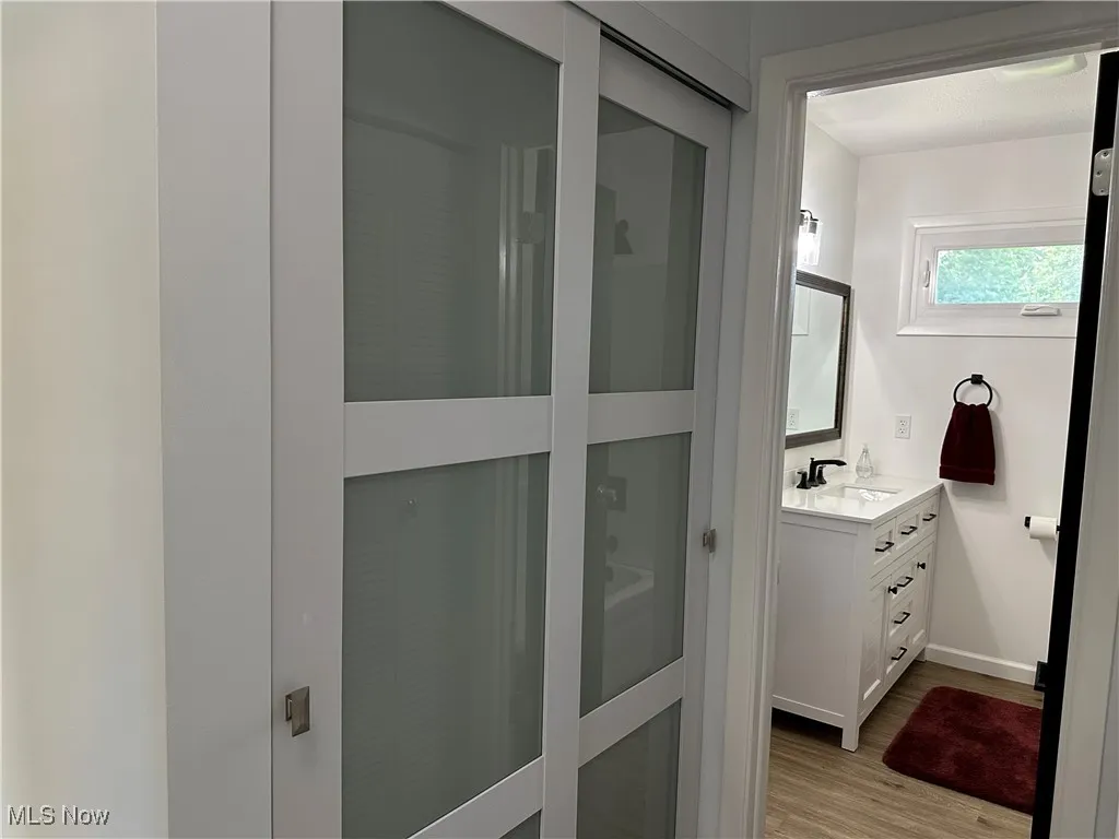 Full bath featuring vanity and wood finished floors
