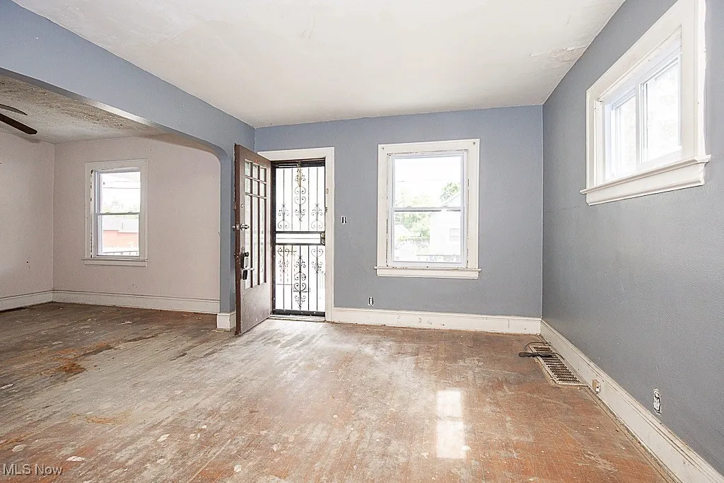 Entrance foyer with healthy amount of natural light, wood finished floors, a ceiling fan, and arched walkways