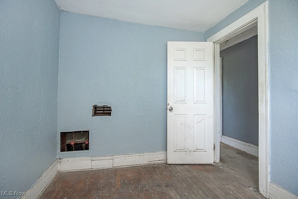 Spare room featuring hardwood / wood-style flooring and baseboards