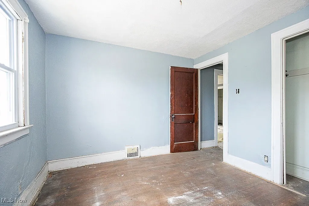 Unfurnished bedroom with hardwood / wood-style floors and a closet